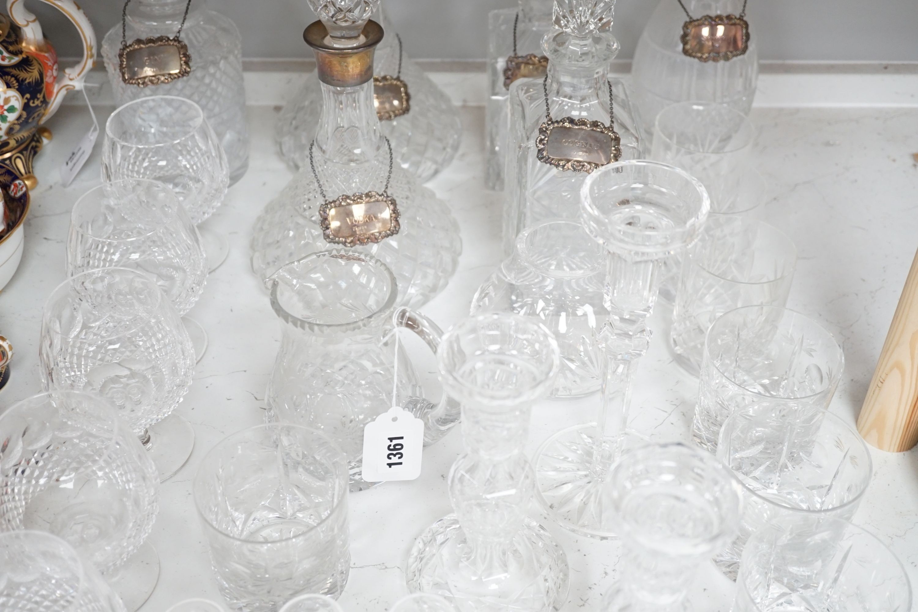 Assorted glassware including six decanters, each with a modern silver wine label